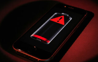 A dead iPhone battery with a red warning sign indicating it needs to be replaced.