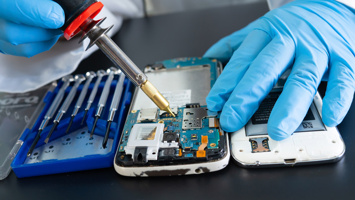 Friendly technician helping a customer with a phone repair in a local repair shop.