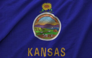 Flag of Kansas displaying the state motto, "Ad Astra Per Aspera."